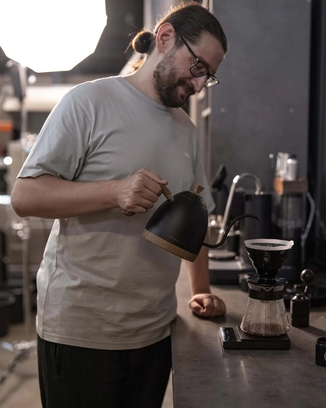 Barista sip25 la bar, turnând apă peste cafea
